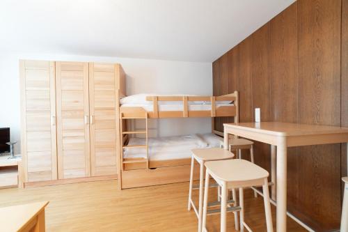 a small room with bunk beds and a table and chairs at Hotel Sonne in Wildhaus