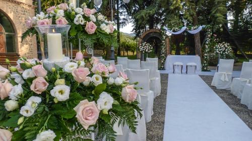 a wedding aisle with white chairs and pink roses at Relais Il Mulino in Corigliano Calabro