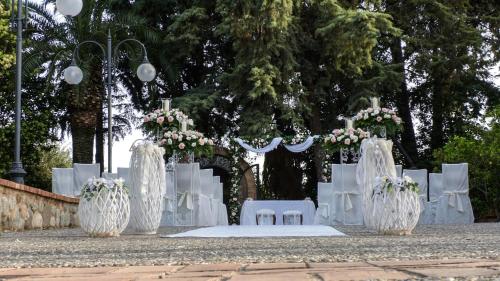 a white wedding altar with white chairs and flowers at Relais Il Mulino in Corigliano Calabro