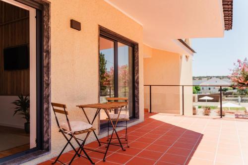 a patio with a table and chairs on a balcony at VILLA DOS R'S in Avis