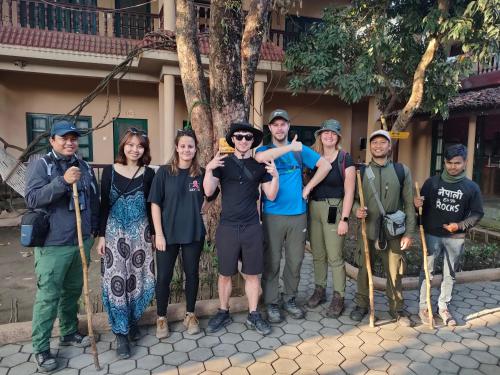 a group of tourists posing for a picture in front of a building at Wild Horizons Guest House in Sauraha