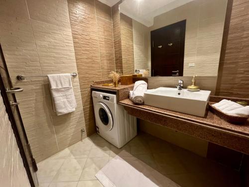 a bathroom with a sink and a washing machine at Beautiful Seaview apartment in Tawaya Sahl Hashish in Hurghada