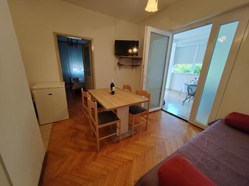 un soggiorno con tavolo in legno e una sala da pranzo. di Apartments Kocijan a Sukošan (San Cassiano)