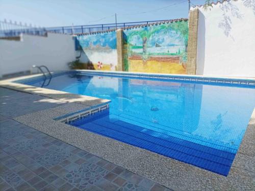 a large blue swimming pool with a mural on a wall at Chalet privado buenas noches in Estepona