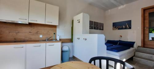 eine Küche mit einem weißen Kühlschrank und einem Tisch in der Unterkunft Kleine Ferienwohnung für Zwei zwischen Allgäu und Bodensee 