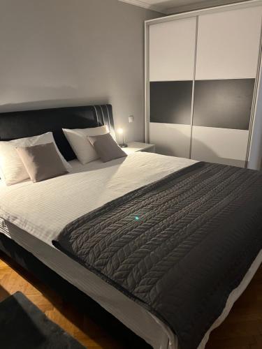 Apartman Loft 72 في سلافونسكي برود: غرفة نوم مع سرير كبير مع لحاف أسود