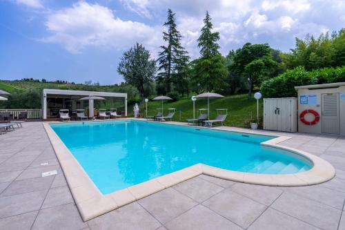 a swimming pool with blue water in a yard at Villa Ca' Viola Rimini in Rimini