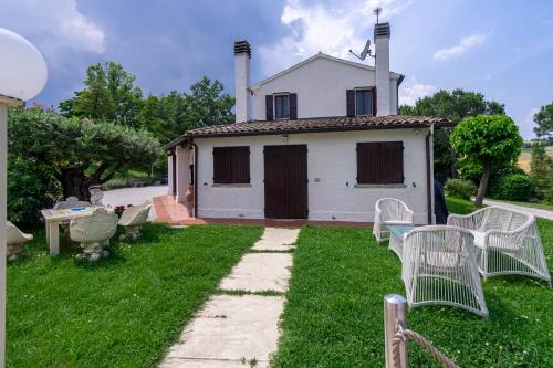 a house with white chairs in front of it at Villa Ca' Viola Rimini in Rimini