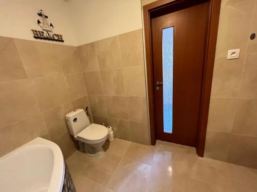 a bathroom with a toilet and a sink and a door at Dom ALEX pri kúpalisku Thermalpark in Dunajská Streda