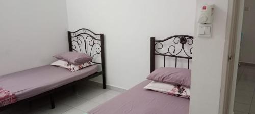 um quarto com 2 camas com almofadas rosas e roxas em Homestay Abu Ayn Islam em Tapah