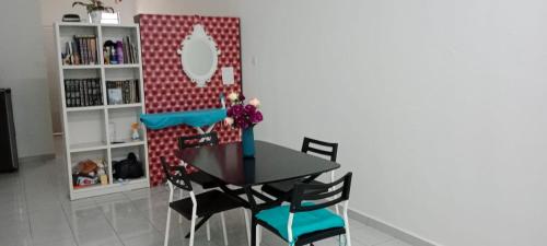 a dining room table with chairs and a mirror at Homestay Abu Ayn Islam in Tapah