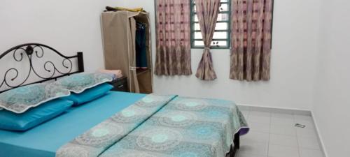 a bedroom with a bed with blue sheets and a window at Homestay Abu Ayn Islam in Tapah