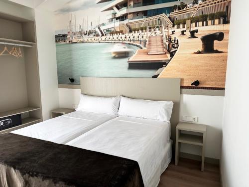 a bedroom with a large bed with a painting of a harbor at Hotel BESTPRICE Valencia in Valencia