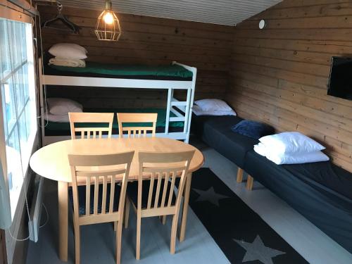 a dining room with a table and chairs and bunk beds at Arctic Camping Finland in Pello