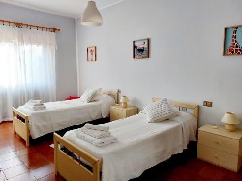 two beds in a room with white walls at Da Marzia apartment in LʼAquila