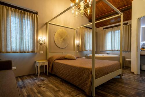 a bedroom with a canopy bed and a bath tub at Villa Ca' Viola Rimini in Rimini