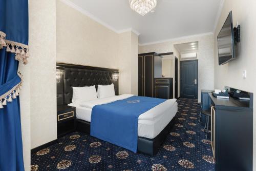 een hotelkamer met een bed met een blauwe deken bij Arcadia City Apartments in Odessa