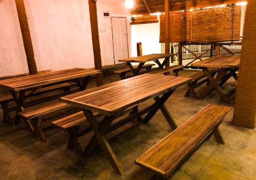 Serenemo Eco Resort في Pundaluoya: صف من المقاعد الخشبية الجالسة في الغرفة