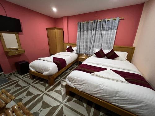 - 2 lits dans une chambre aux murs roses dans l'établissement Happy Home Guest House, à Pokhara