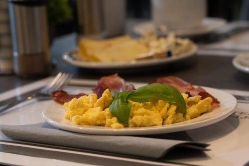 a plate of scrambled eggs and greens on a table at Hotel Grille in Erlangen