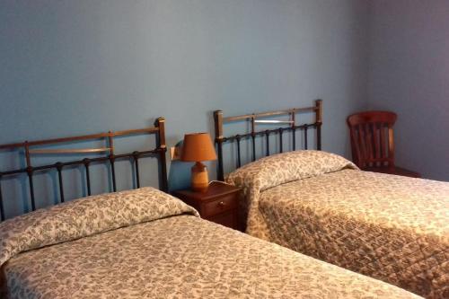 Sequeros的住宿－PRECIOSO APARTAMENTO RURAL，一间卧室设有两张床和一张桌子上的台灯。