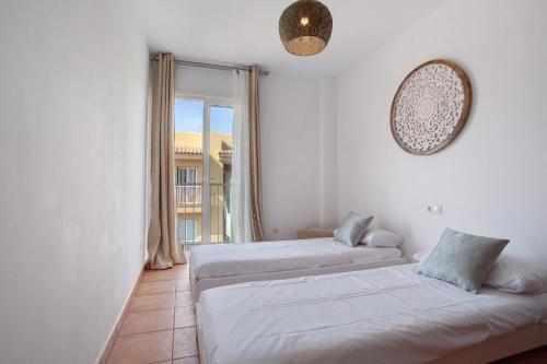 two beds in a room with a window at Luxury Ocean View - Carpe Mundi in Corralejo