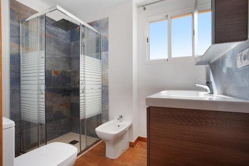 a bathroom with a toilet and a sink and a shower at Luxury Ocean View - Carpe Mundi in Corralejo