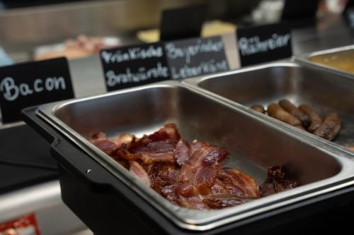 a metal tray of food with meat and beans at Hotel Grille in Erlangen