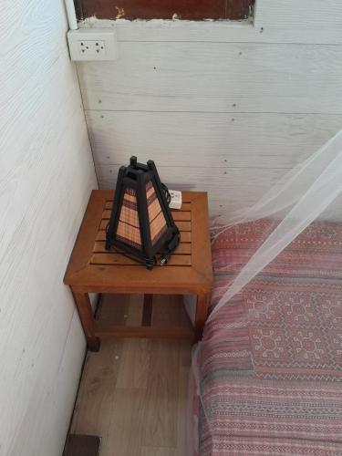 a small table sitting next to a bed in a room at Pikban in Chiang Rai