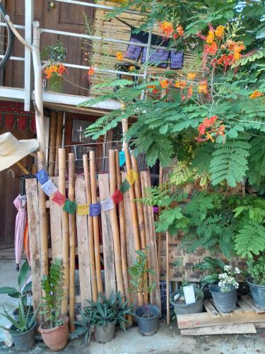 a wooden fence with a bunch of plants and flowers at Pikban in Chiang Rai