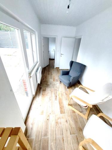 a living room with a blue chair and a table at Studio Autonome Mont Saint Guibert in Mont-Saint-Guibert