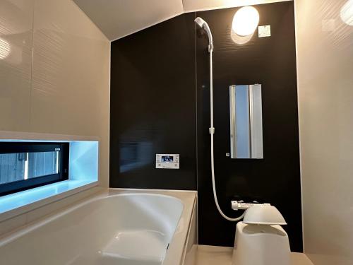 a bathroom with a bath tub and a tv at 游月庵 in Inuyama