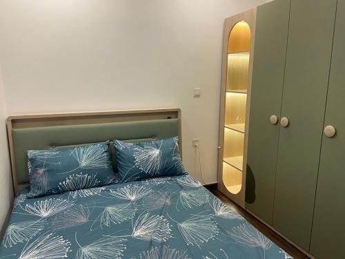 1 dormitorio con 1 cama con sábanas azules y espejo en Căn hộ Hoàng Huy Grand, en Hai Phong