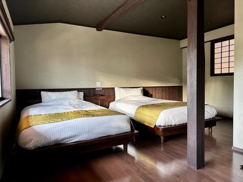 a bedroom with two beds and a window at 游月庵 in Inuyama