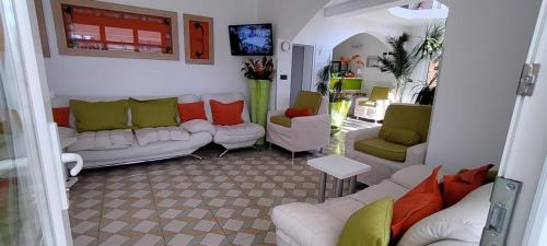 uma sala de estar com sofás brancos e almofadas coloridas em Pensiunea Sergiu & Geanina em Arad