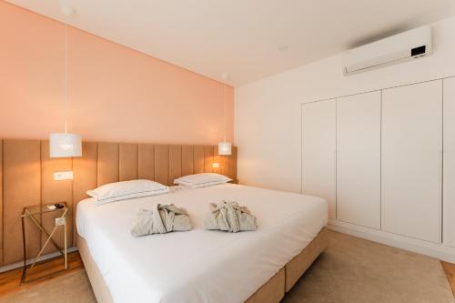 a bedroom with a large white bed with two pillows at VILLA DOS R'S in Avis