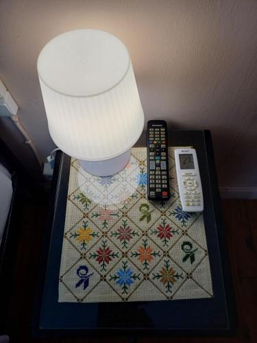 a table with a lamp and remote controls on it at Lefkada Family Apartment in Lefkada Town