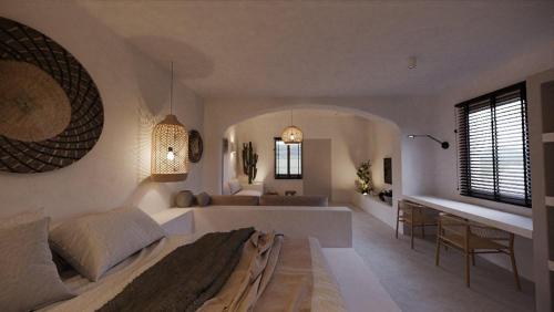 a bedroom with a large bed and a desk at Lejardin suites santorini in Pirgos