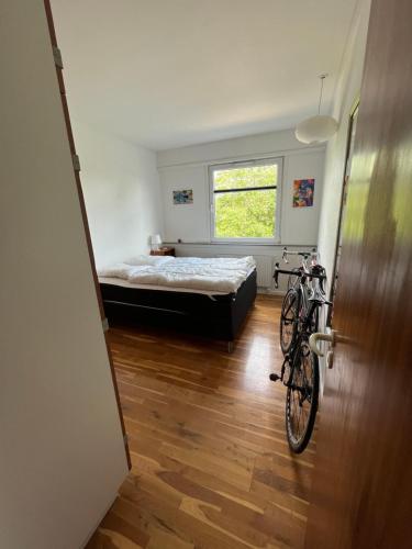 a bedroom with a bed and a bike in a room at Skelvangsvej in Randers