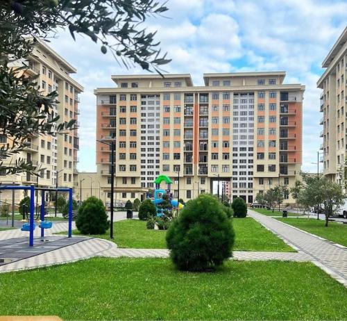 a large building with a playground in a park at Levent beach 1,Luxury apartment in Sumqayyt