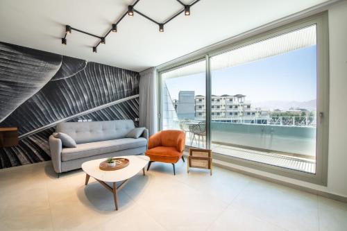 a living room with a couch and a table at Beach Side-Kings Luxury Sea view Amazing Pool Eilat in Eilat