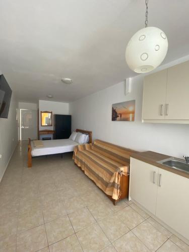 a bedroom with a bed and a sink in it at Sisamis Studios Pigadia Karpathos in Karpathos Town