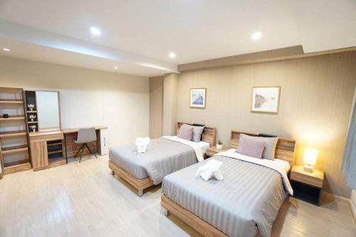 a hotel room with two beds and a desk at Maruay Living Apartment 509 (Khaosan/Chinatown/Samyot MRT) in Bangkok
