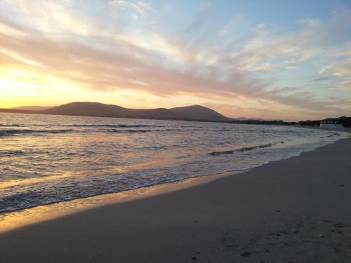 a view of the beach at sunset at Hotel Mistral in Alghero