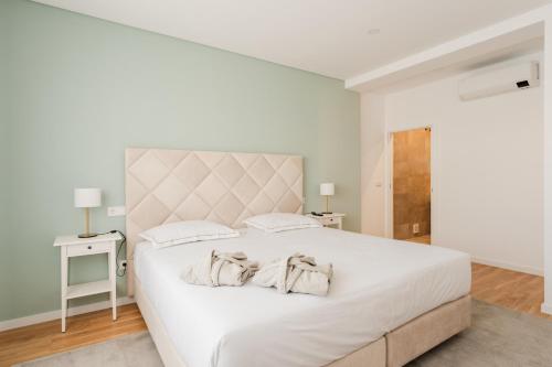a white bedroom with a large white bed with two pillows at VILLA DOS R'S in Avis