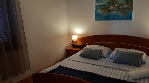 Apartment Delfina في Ist: غرفة نوم مع سرير مع وسادتين