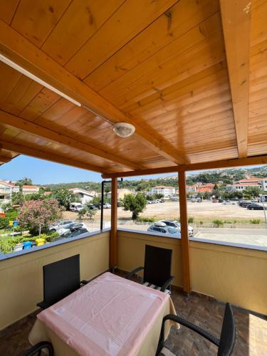 d'un balcon avec une table et des chaises et une vue sur le parking. dans l'établissement Apartments and Rooms Markovski, à Rab