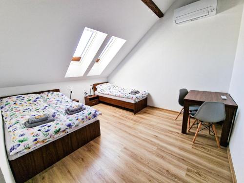 a bedroom with two beds and a desk and a table at GraVelo - Noclegi in Bartkowa-Posadowa