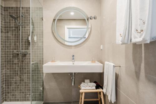 a bathroom with a sink and a mirror and a shower at VILLA DOS R'S in Avis