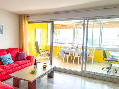 a living room with a red couch and a table at Horizon YourHostHelper in Saint-Laurent-du-Var